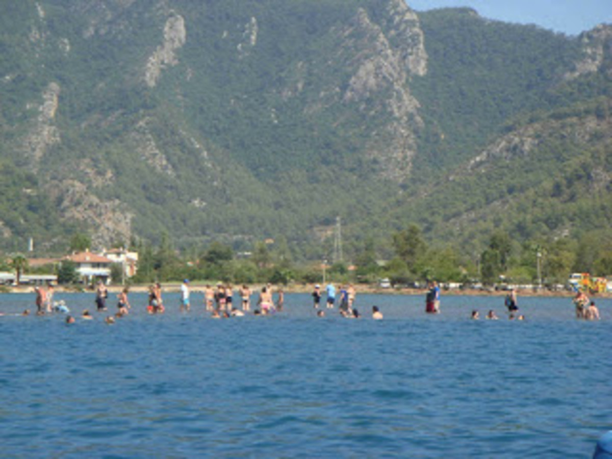 The mostly submerged sand bar gives swimmers the appearance of walking on water.
