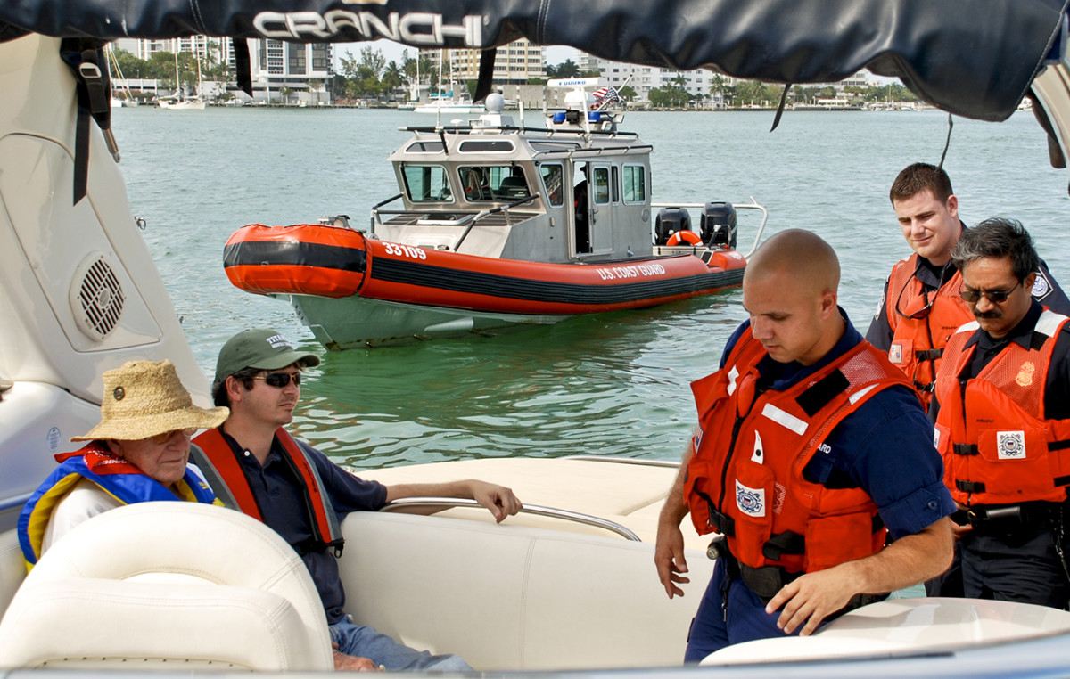 Operating under unique and specific orders from USCG ISC Miami, Flotilla 6-11 members Robert Evans (left) and James Carlin pose as civilian subjects of interest during a training evolution with boarding personnel from USCG Station Miami Beach and the Miami office of U.S. Customs and Border Protection (CPB) practicing new joint operations.  This evolution took place aboard the Auxiliary Facility "After Party" and highlights one of the many examples in which members of the Auxiliary are assisting those agencies tasked with protecting the borders and ports of the United States of America. Photo by  Christopher Todd, USCGAUX.