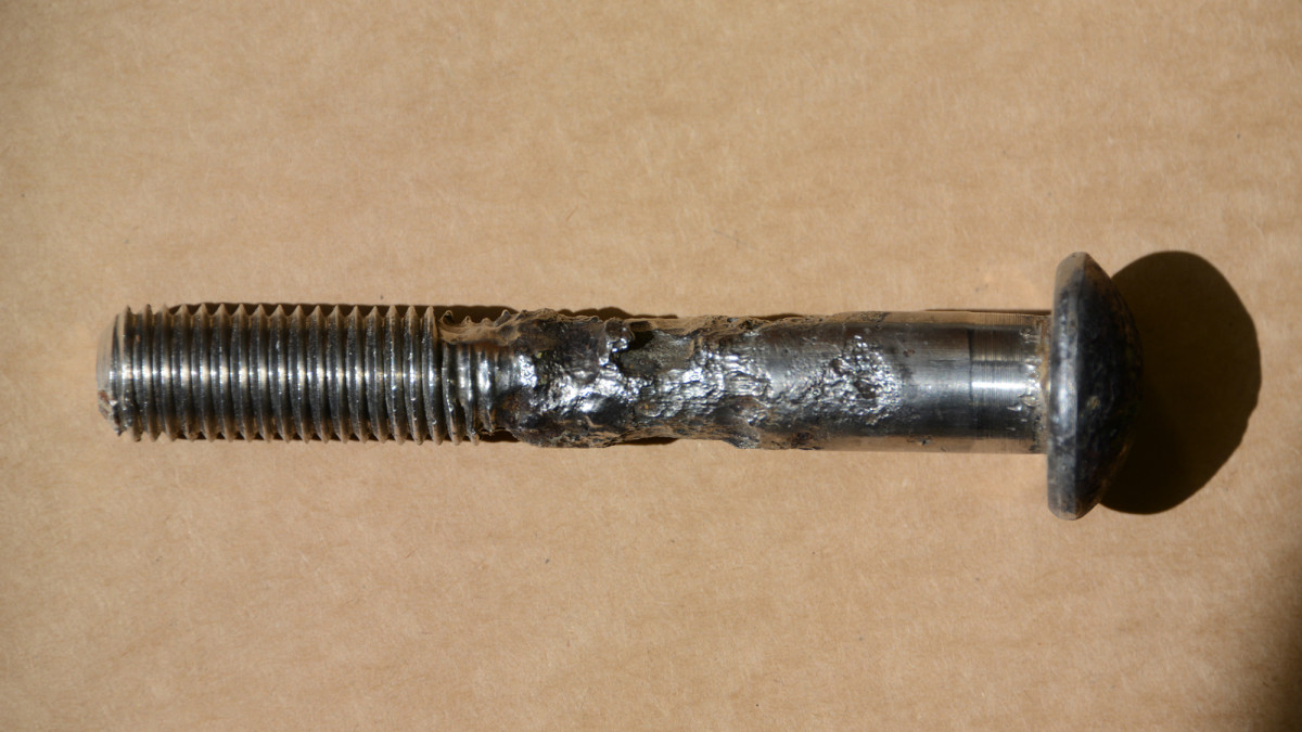 The fastener above is in good shape at the head and the threads, but a lack of oxygen where the bolt passes through the laminate has caused the metal to deteriorate, forming a waist.