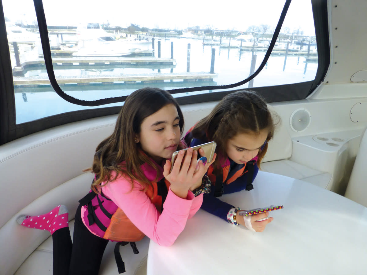 The author’s daughters, Molly and Madelyn, were happily connected to YouTube during a 14-month cruise on the family’s Carver Voyager 57.