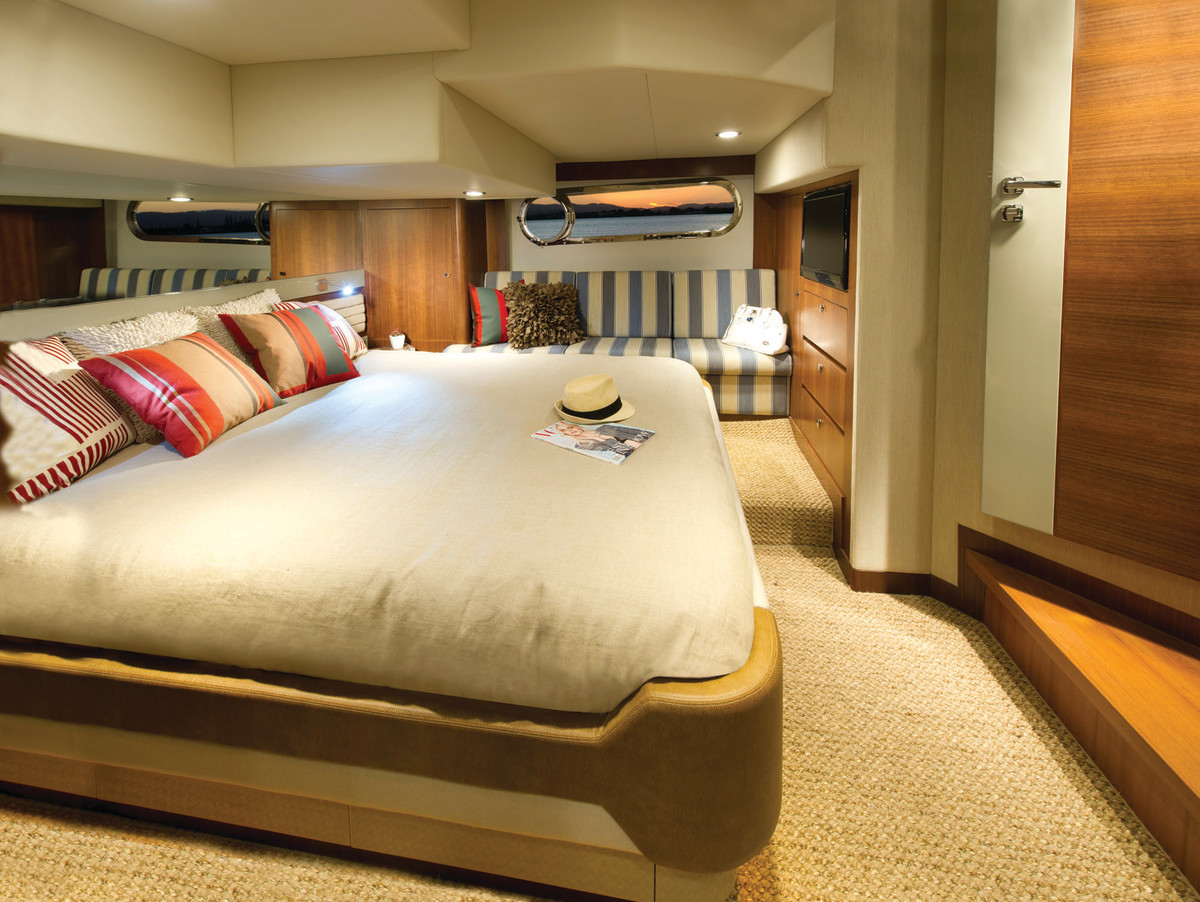 The master stateroom offers a walkaround and tasteful interior design employing beautiful textiles, carpet, and book-matched wood joinery.
