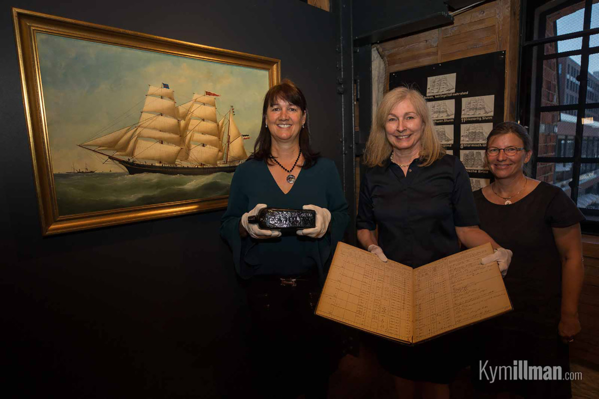 Tonya Illman presents the bottle alongside a painting of Paula and the original journal from the ship.