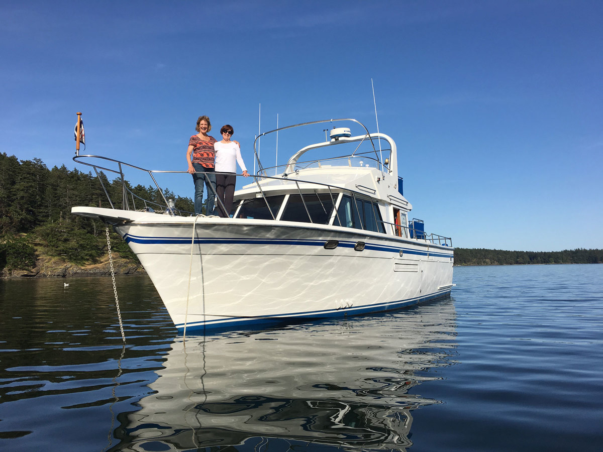 The classic 40-foot DeFever Caliente looks quite comfortable in Westcott Bay, San Juan Islands, as do guests Cathy and Vanita. 