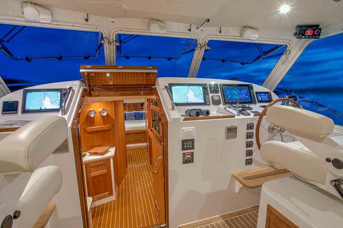 With the windows open, guests can enjoy an open flybridge effect from deck level. Note the pilot/co-pilot helm seating arrangement. 