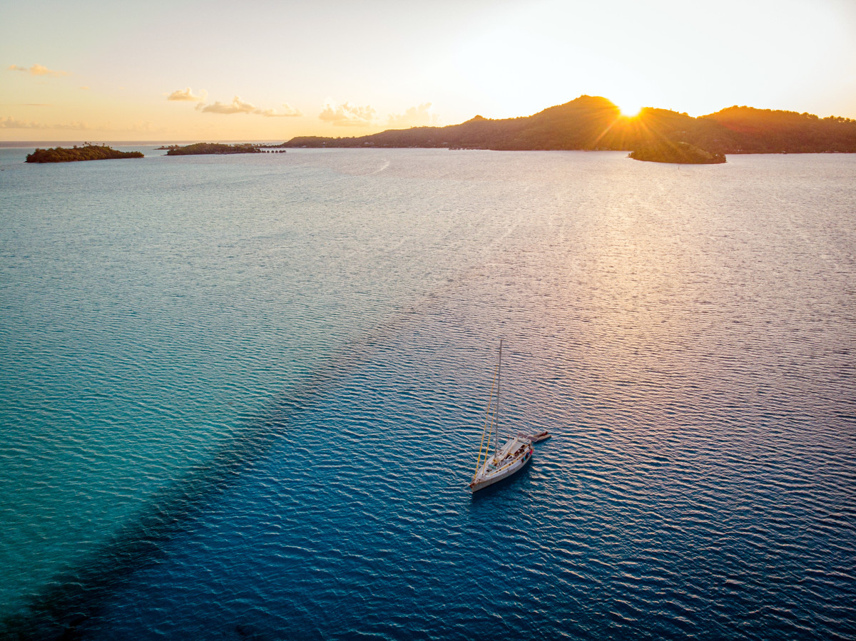 As the sun slides behind Bora Bora, vivid color patterns illuminate abrupt depth changes in the lagoon.
