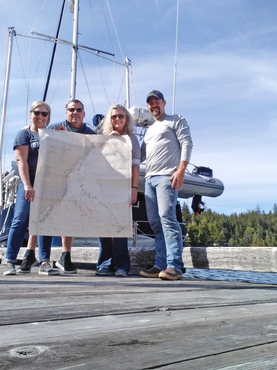 The crew poses with a map of their 2,500- nautical-mile journey across the Pacific.  