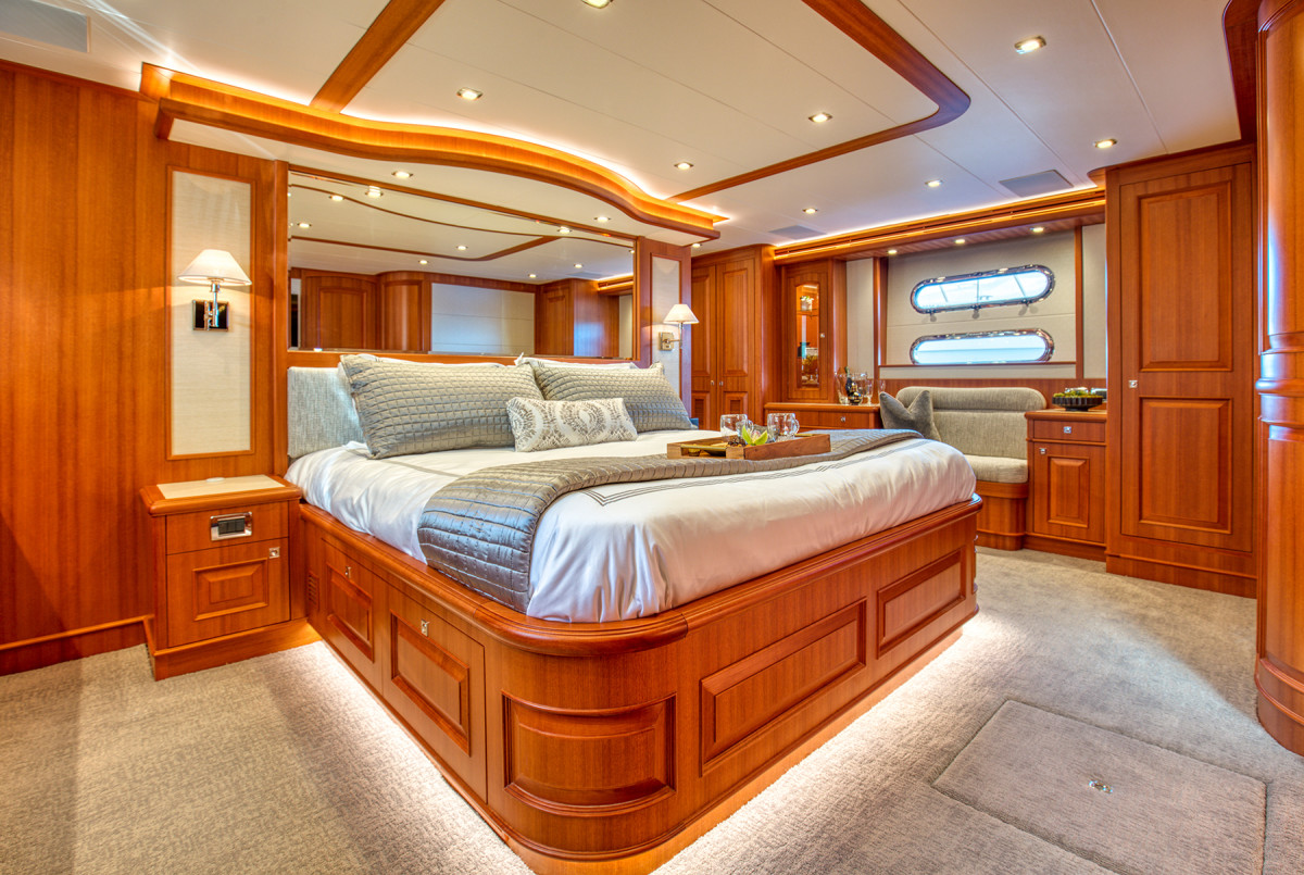 The full-beam master stateroom features a walkaround king berth. The African cherry trim continues belowdecks, expanding on the interior design theme.